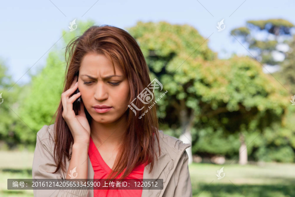 在一個明亮的草原地區(qū)，女人向下看，一邊打電話