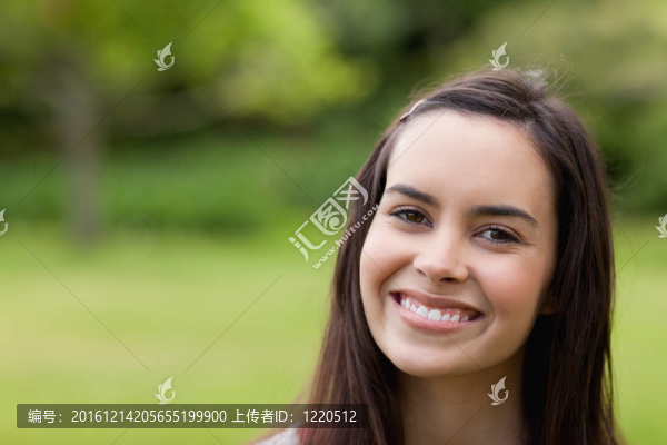 年輕快樂的女人站在鄉(xiāng)下看著相機