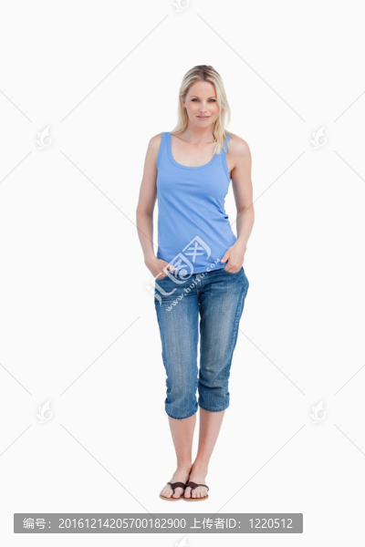 輕松的金發(fā)女子站在手直立在口袋里
