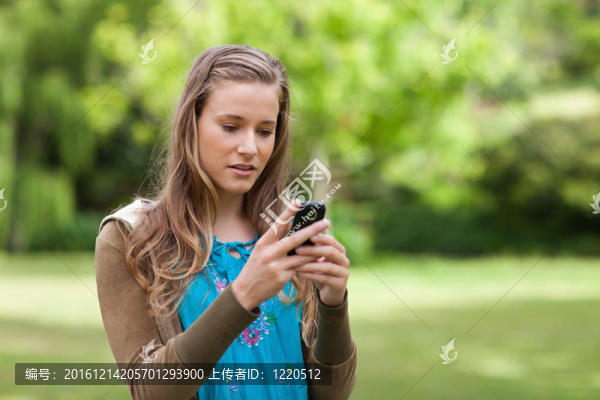 嚴重的少女發(fā)送文本，而站在公園里