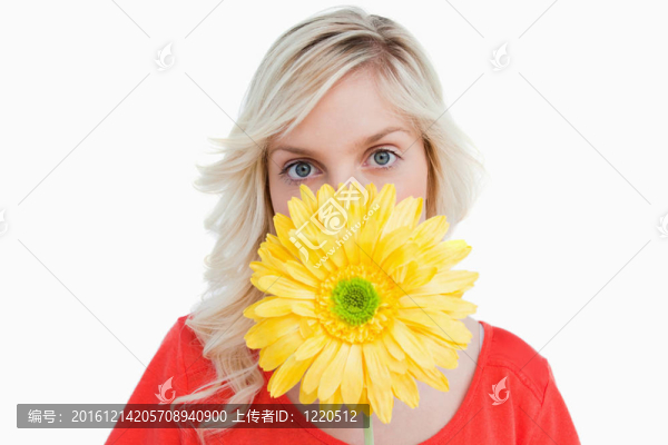 金發(fā)女人藏在黃色的花后面的臉