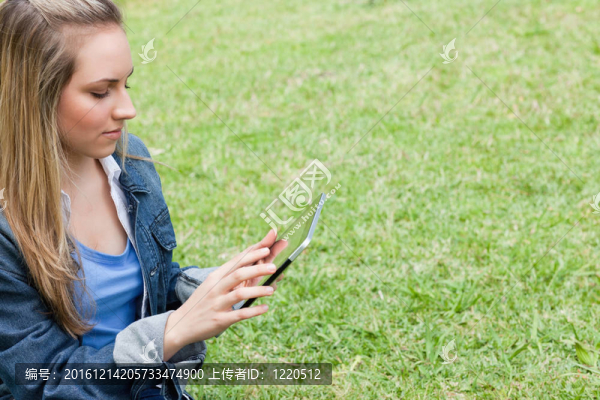 年輕的女孩用她嚴(yán)重的平板電腦在農(nóng)村
