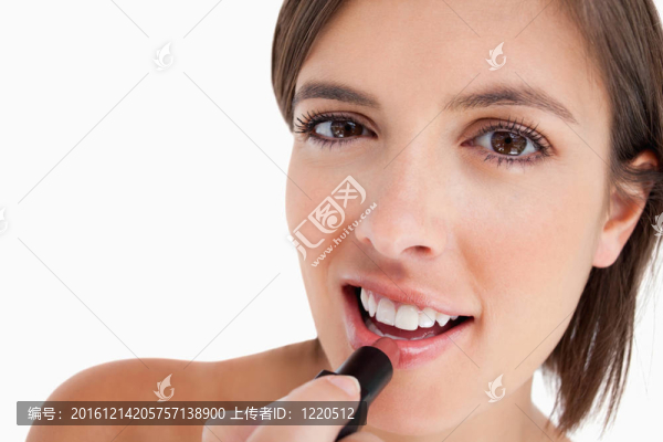 微笑的少女在化妝時涂口紅