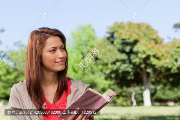 女人傻笑朝一邊讀一本書(shū)