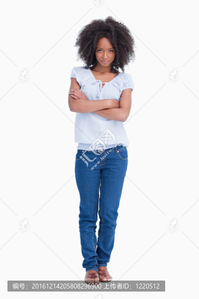 一個年輕的嚴肅女人交叉著雙臂站著