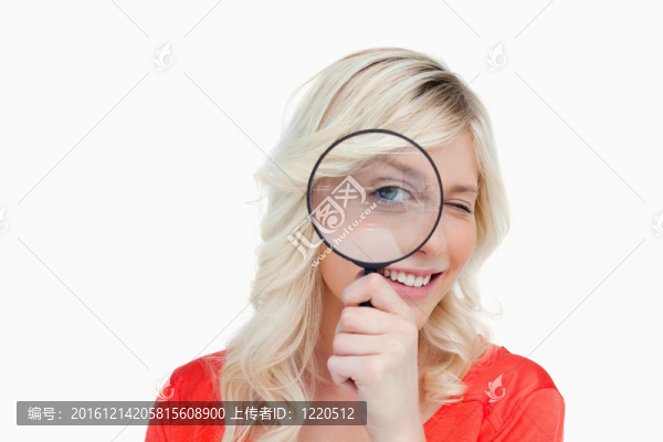 女人用放大鏡看眼睛的同時