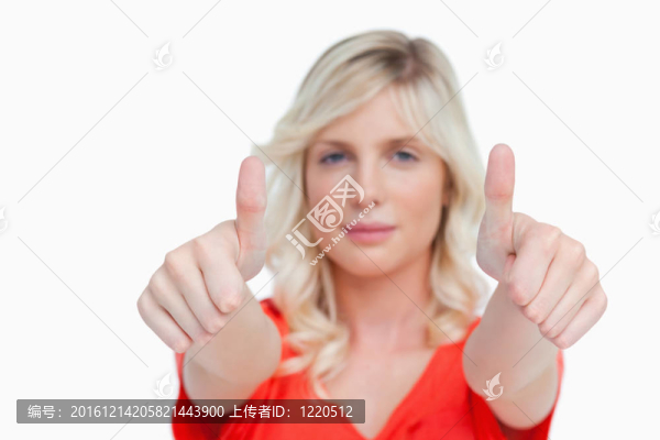 一個年輕漂亮的女人展示了兩個大拇指