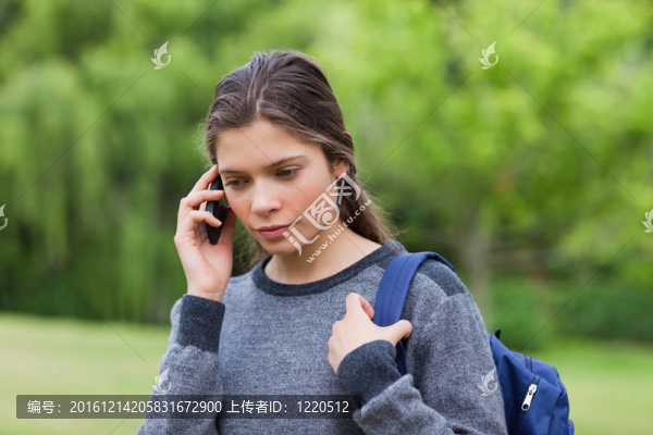 體貼的年輕女孩一邊背著她的手機(jī)
