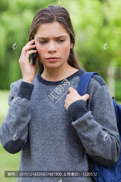 認真的學生在電話邊往下看