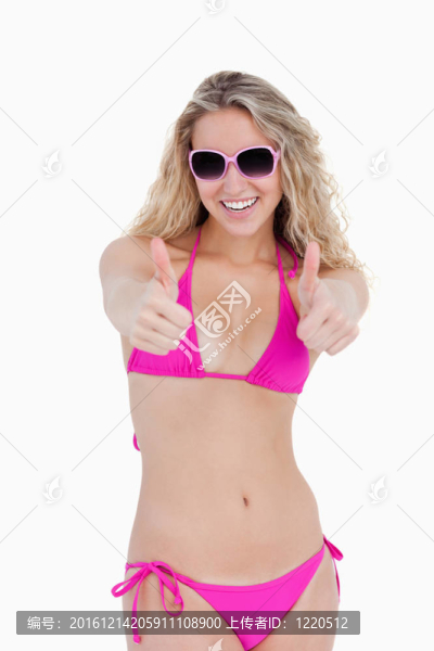 十幾歲的女孩在海灘把她的大拇指在白色背景