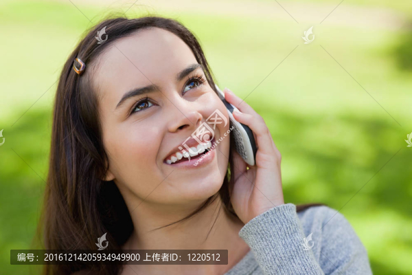年輕的微笑女人一邊看著電話一邊聊天