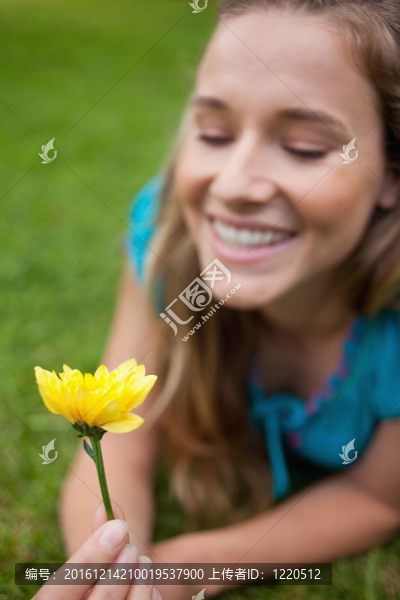 黃色的花由一個微笑的少女