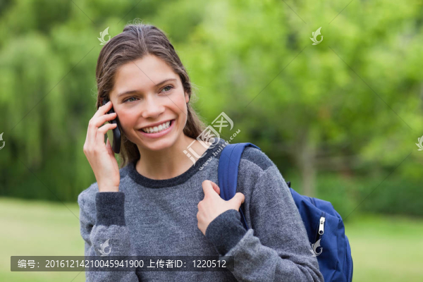 年輕的微笑女孩一邊看一邊看電話