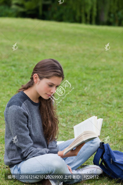 年輕女子一邊看書一邊交叉雙腿