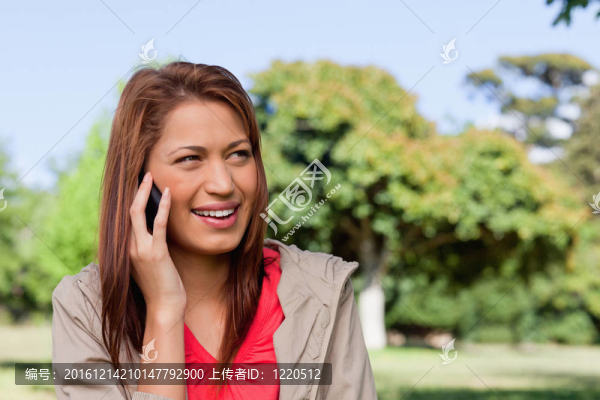 女人微笑著看著她左邊的一個明亮的區(qū)域周圍樹木