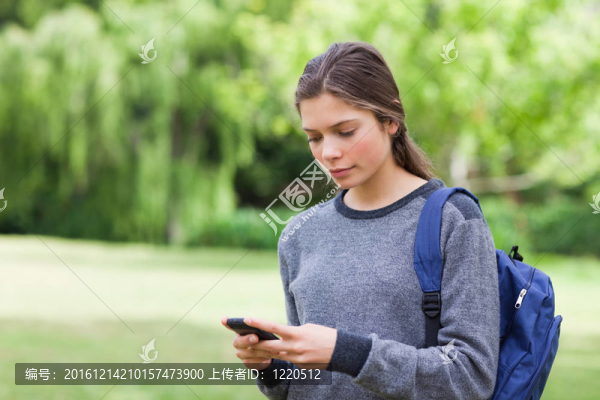 年輕淡定女孩用手機(jī)發(fā)短信