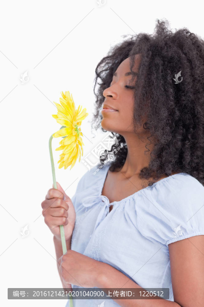 年輕的卷發(fā)女人聞到美麗的花朵