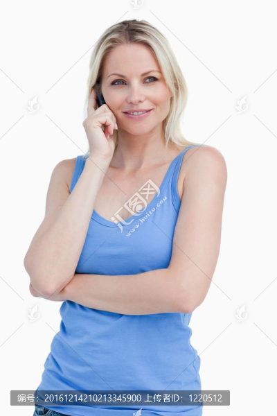 金發(fā)女人用手機站著，雙臂交叉