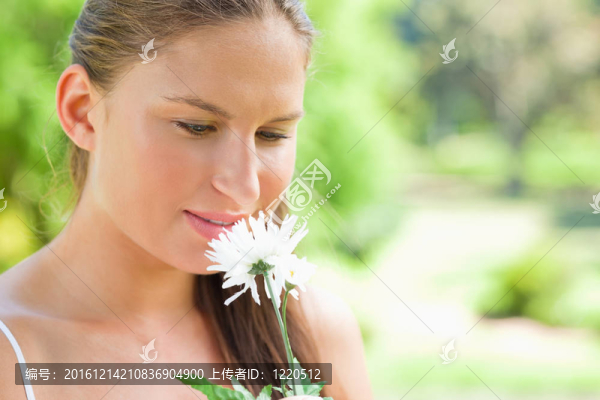 在公園里聞到白色花的女人