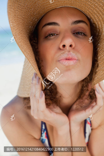 年輕女子戴著草帽而蹙起她的嘴唇