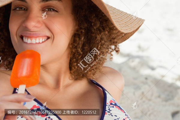 年輕漂亮的女人要在海灘上吃美味的冰淇淋