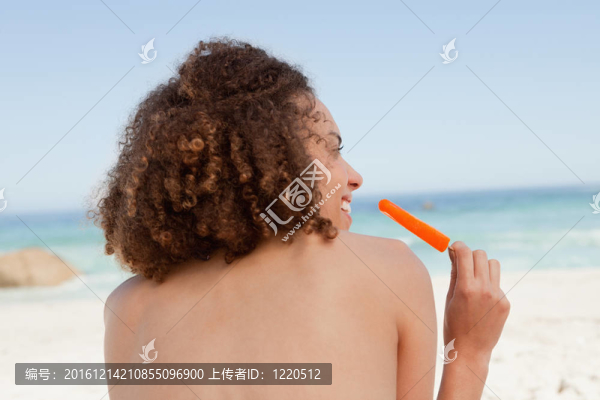 微笑的魅力的女人抱著一個橙色的冰棍