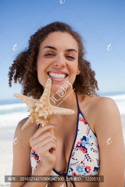 微笑的年輕女子驕傲地抱著海星