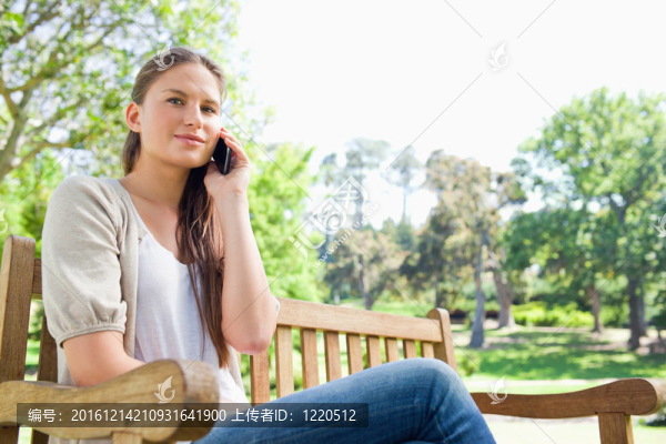女人在公園長(zhǎng)椅上的電話