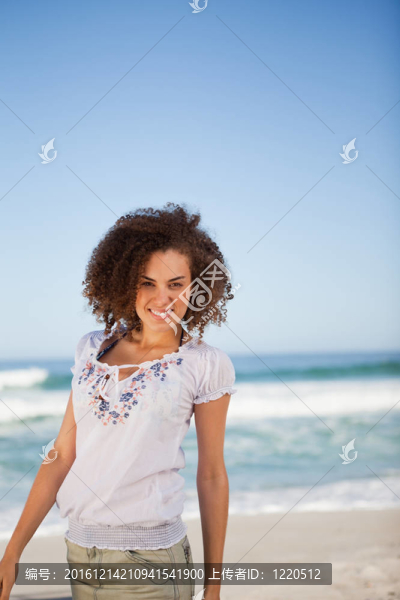 站在海灘上的年輕微笑的女人