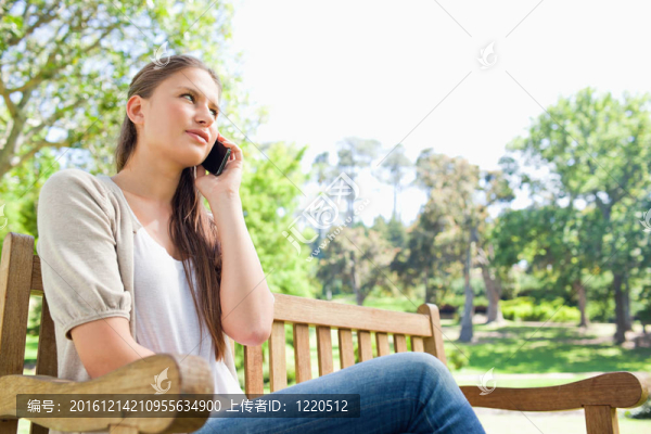 女人在公園長(zhǎng)椅上打電話