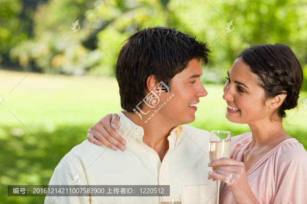 女人抱著一杯香檳看著她的朋友