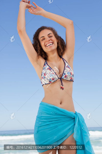 微笑的年輕女子舉起雙臂表示她的幸福