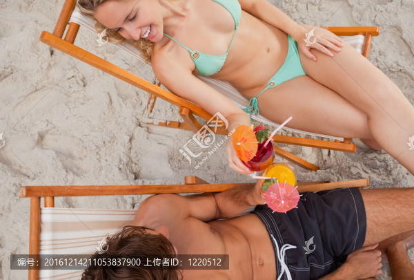 一個(gè)微笑的夫婦無(wú)比的眼鏡坐在躺椅上俯視