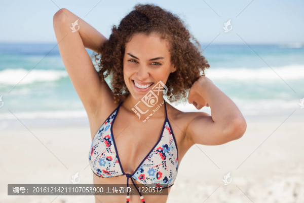 年輕的微笑女人把手放在頭后面