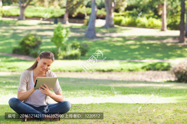 在公園里帶著平板電腦的女人