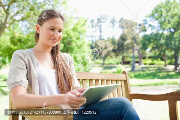 微笑的女人在公園長椅上用藥片