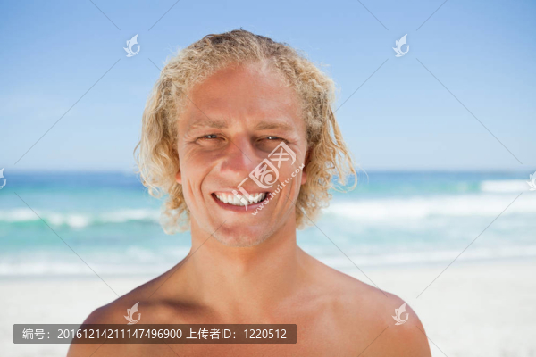 站在海灘上的年輕微笑的人