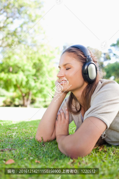 一個女人在草坪上欣賞音樂的側(cè)面