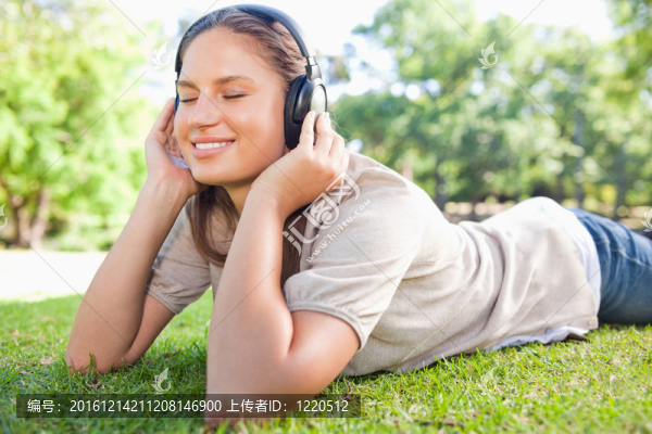 在草坪上享受音樂(lè)的女人