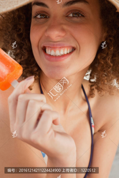 年輕的女人呈現(xiàn)出巨大的微笑一邊拿著冰棒