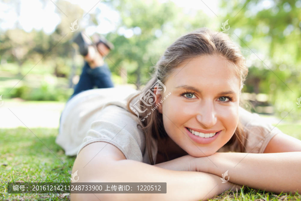 微笑的女人躺在草坪上