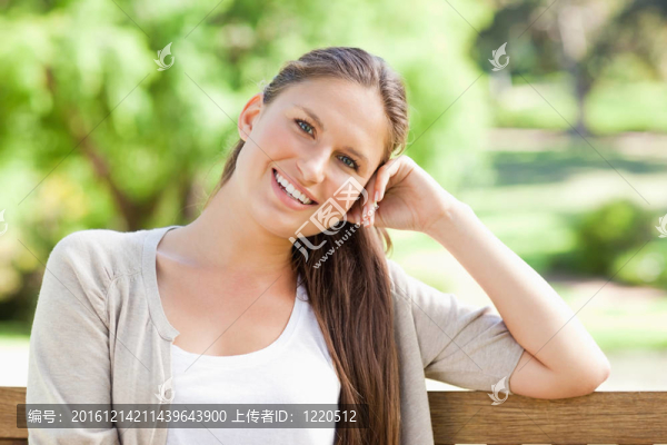 微笑的女人在長椅上享受她的日子