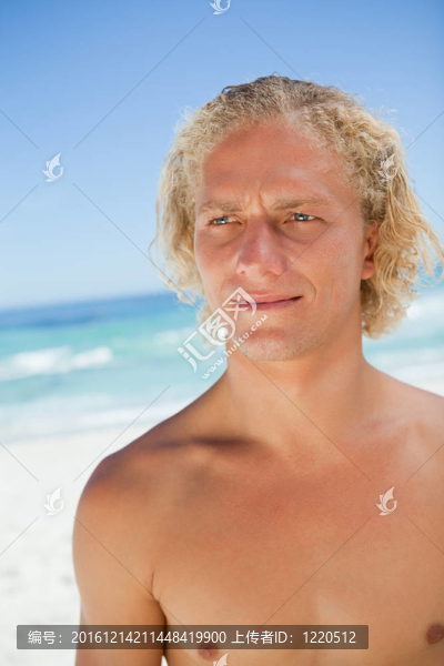一個嚴肅的人站在海邊看著一邊