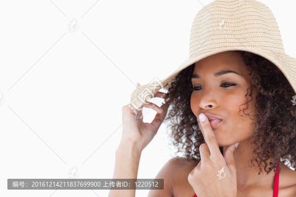 年輕的黑發(fā)女人把她的手指放在嘴里
