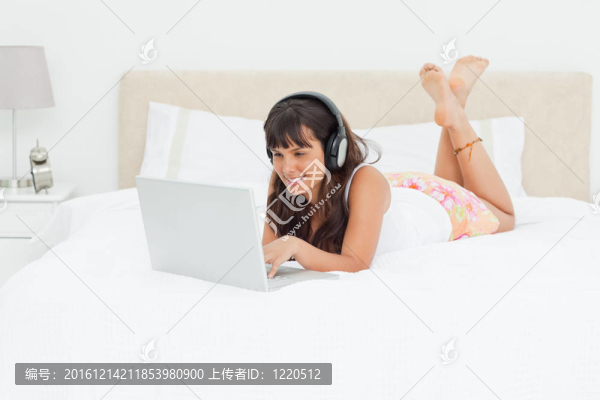 年輕的女人在一個(gè)筆記本電腦用耳機(jī)聊天