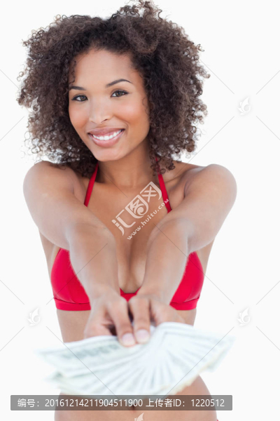 微笑的黑發(fā)女人直立而拿著扇子紙幣