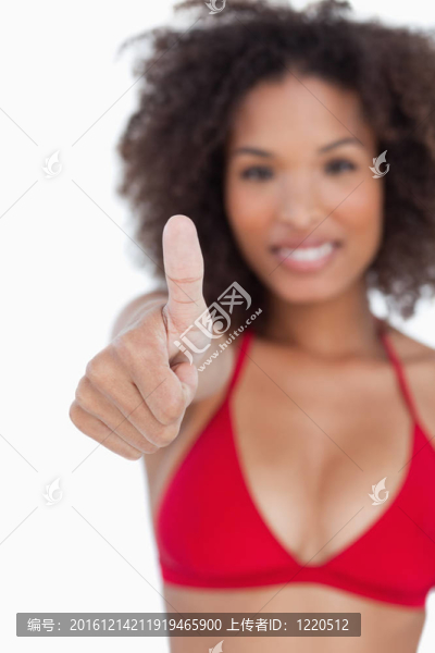 豎起大拇指，表現(xiàn)出一個年輕的黑發(fā)女人