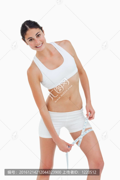 苗條的女人測量她的大腿