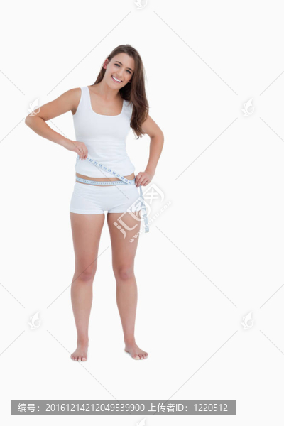 微笑的黑發(fā)女人測(cè)量她的腰