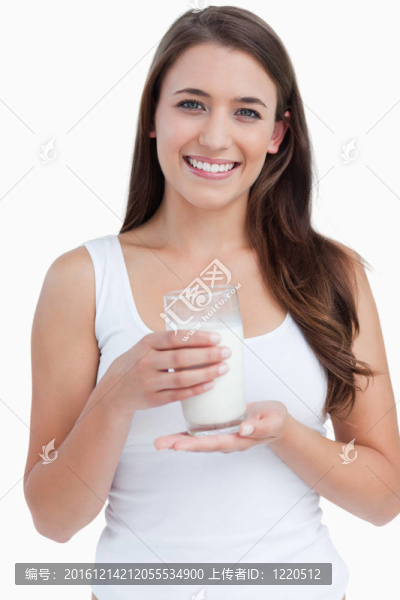 微笑的女人拿著一杯牛奶
